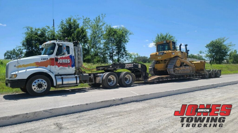 18-ton tractor secured onto lowboy trailer by Construction Equipment Towing team